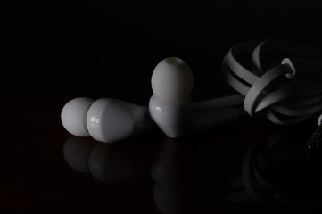 new white in-ear headphones, Concept photo with dramatic light, copy space and black background