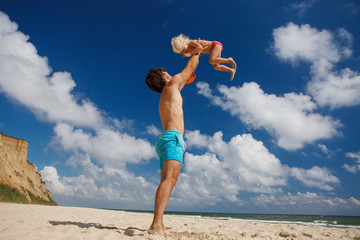 happy family father and daughter relax and play by the sea on the beach in summer