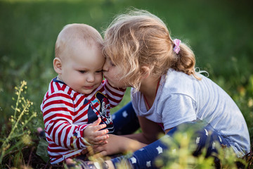 little girl is kissing her small brother