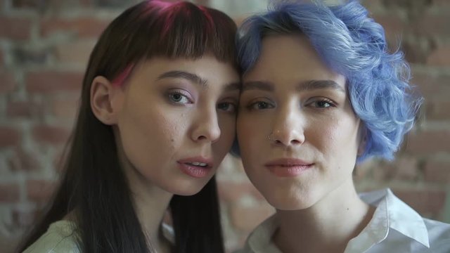 Two young smiling hipster women Spbd. Models young womans with bright colorful hair posing on room background. Female showing positive face emotions. concept hairstyle, people