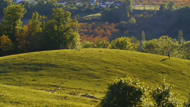 Un homme fait son footing en contre-jour dans la nature au abord des haute alpes lors d'un magnifique coucher de soleil.