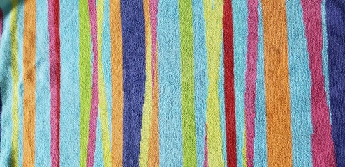 Bright, colorful striped design on a beach towel.