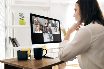 Video call. Remote work. A girl work from home. She communicate via video communication with colleagues using computer