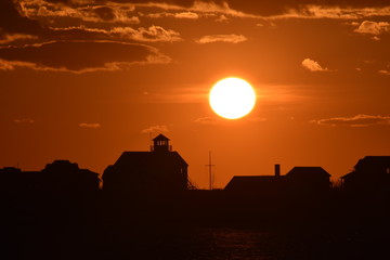 silhouette of lighthouse against sunset 