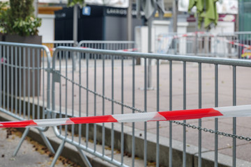 Fototapeta na wymiar Selected focus at Red and white caution tape restrict outdoor eating area of cafe and restaurant which closed during epidemic of COVID-19 virus. COVID-19 restrictions on restaurant business in Europe.