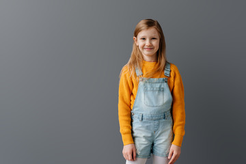 Portrait of a emotional beautiful little girl. Isolated on grey background