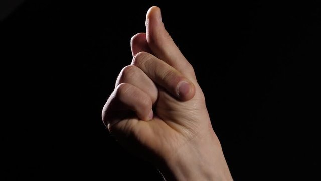 Man's hand snap finger on black background