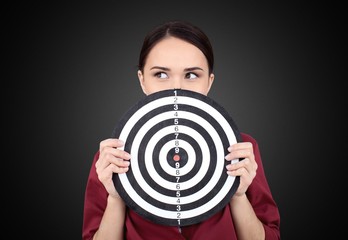 Beautiful businesswoman portrait holding round target of darts