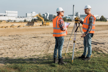 Two road construction workers using measuring device on the field