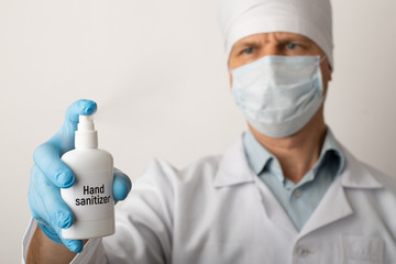 Doctor holding hand sanitizer gel in studio. Sanitizing hands of a patient before examination