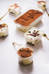 Tiramisu in different shape, various form of serving tiramisu, on glasses, classic, and as a round cake,