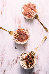 Tiramisu served on small  glasses, with golden fork