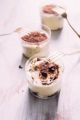 Tiramisu served on small  glasses, with golden fork