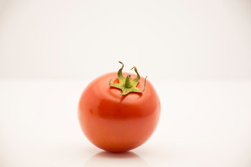 Fresh red tomato on white background.