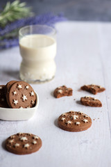 Homemade round brown crispy cookies and a glass of fresh milk