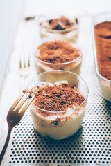 Tiramisu served on small  glasses, with golden fork