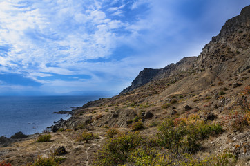 Fototapeta na wymiar Mountain seascape, mountain vegetation and mountain trails on the coast.