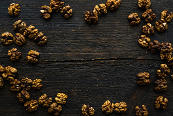 Walnut scattered on the wooden vintage table. Copy space. Walnuts is a healthy vegetarian protein nutritious food. Almonds on rustic old wood.