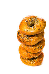 Stack Bagels Topped with Sesame Seeds, Poppy Seeds, Garlic and Onion Isolated on White Background. Selective focus.