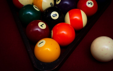 Billiard balls racked in a triangle on a red felt pool table