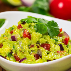 Avocado Guacamole Mexican Dip with Avocado, Lime, Tomato and Cilantro. Selective focus.