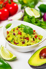 Avocado Guacamole Mexican Dip with Avocado, Lime, Tomato and Cilantro. Selective focus.