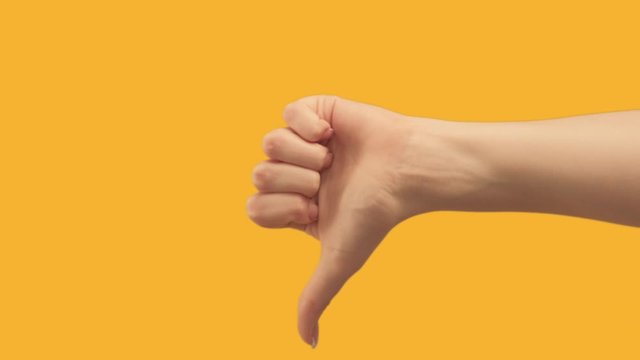Set of 2 hand gestures. Approval dislike. Female thumb up down isolated on copyspace orange background.