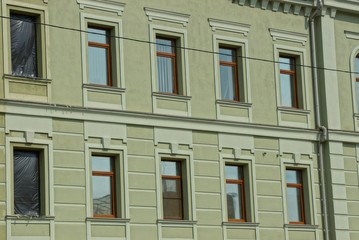 Obraz premium texture of a series of windows on the green concrete wall of a building on the street