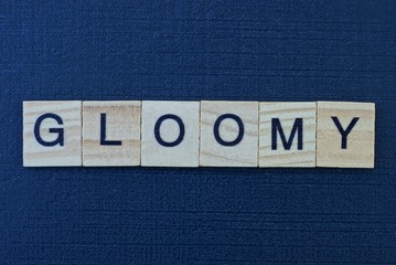 gray word gloomy of square wooden letters on a black dark table