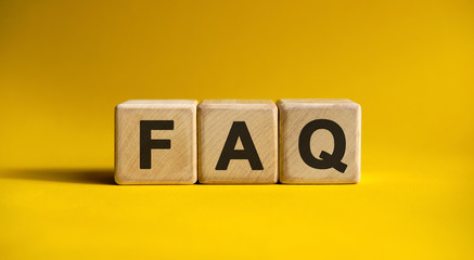 FAQ - text on wooden cubes, on yellow background - obrazy, fototapety, plakaty