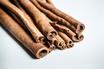 closeup big group of dry cinnamon sticks served on white table surface