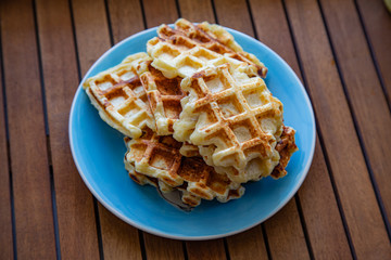 Plate with Belgian waffles with homemade cottage cheese standing on a wooden table. Breakfast for the whole family