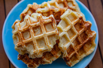 Plate with Belgian waffles with homemade cottage cheese standing on a wooden table. Breakfast for the whole family