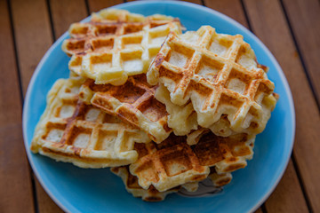 Plate with Belgian waffles with homemade cottage cheese standing on a wooden table. Breakfast for the whole family