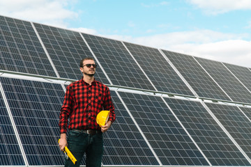 Portrait of a successful young engineer on the background of a solar power station. An engineer...
