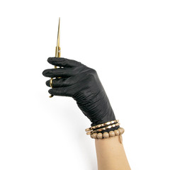 Gloved hand holding a gold scisors on an isolated white background