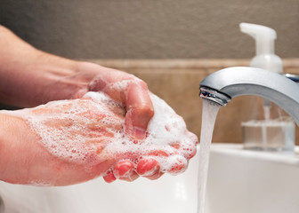 Fototapeta premium Washing hands with soap and water in bathroom sink, protection against viruses and bacteria, hygiene to stay healthy