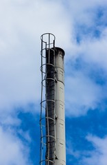 Top of industrial chimney close up. Industrial chimney with utilities. Industrial chimney against sky.