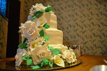 Photo detail of a beautiful white cake decorated with white flowers.