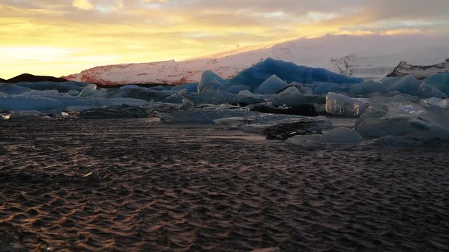 Ice flows in a dramatic sunset color at Diamond Beach, Jokulsarlon lake, - a famous glacier lagoon in Vatnajokull National Park, Iceland
