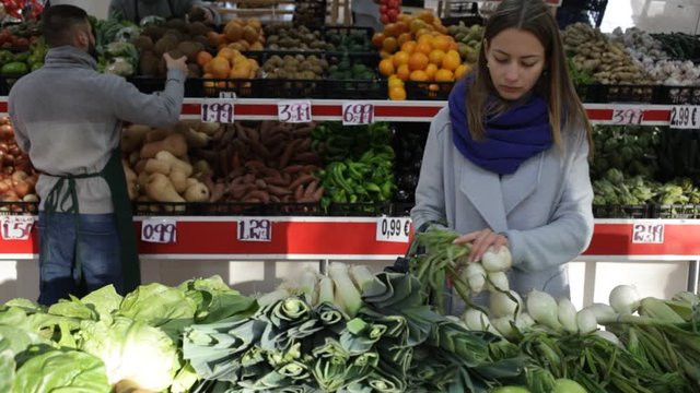 Female shopper picks onions at grocery store