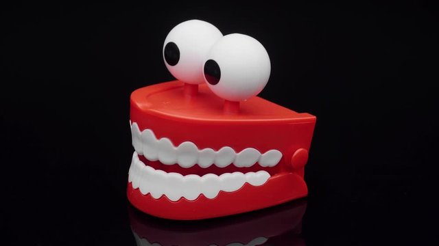 Сhattering teeth toy moving on black background.