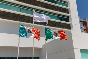 Mexican flags on the background of a modern hospital building.