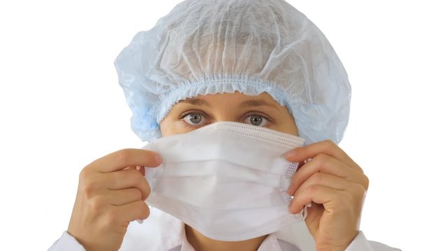 Wear the mask! Female doctor wearing a mask and pointing her finger up on white background.
