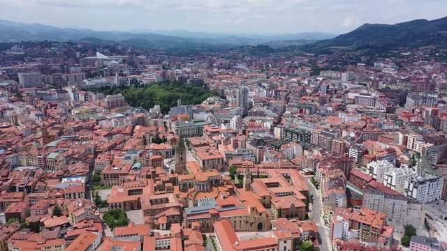 Panoramic aerial view of Oviedo city surrounded by mountain ranges on sunny summer day, Asturias, Spain