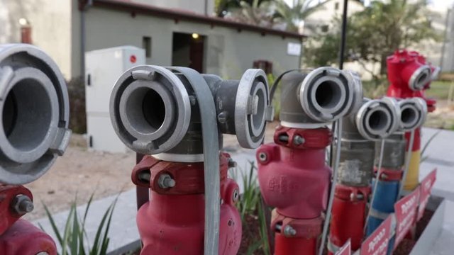 many fire hydrants in a row or crane against the background of urban buildings

