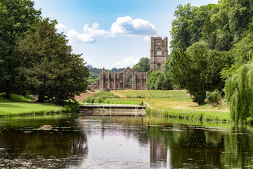 Fountains Abbey and Studley Royal on a warm summer day. - obrazy, fototapety, plakaty