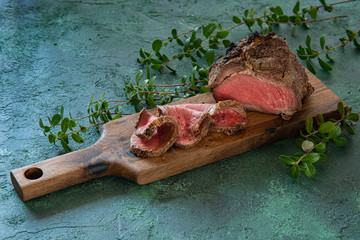  Medium rare roast beef meal with bay leaves on meat fork. Venison, Elk Sirloin Tip Roast. image...