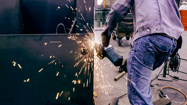 Worker are grinding metal steel, Electricity spark from chainsaw, Technician are cutting pipe, Risk work for electricity in factory