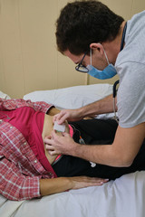 a physician doing a subcutaneous vial for the treatment of an adult woman with covid-19 during the pandemic